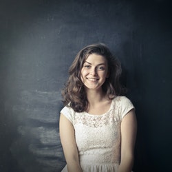 happy woman standing in front of chalkboard